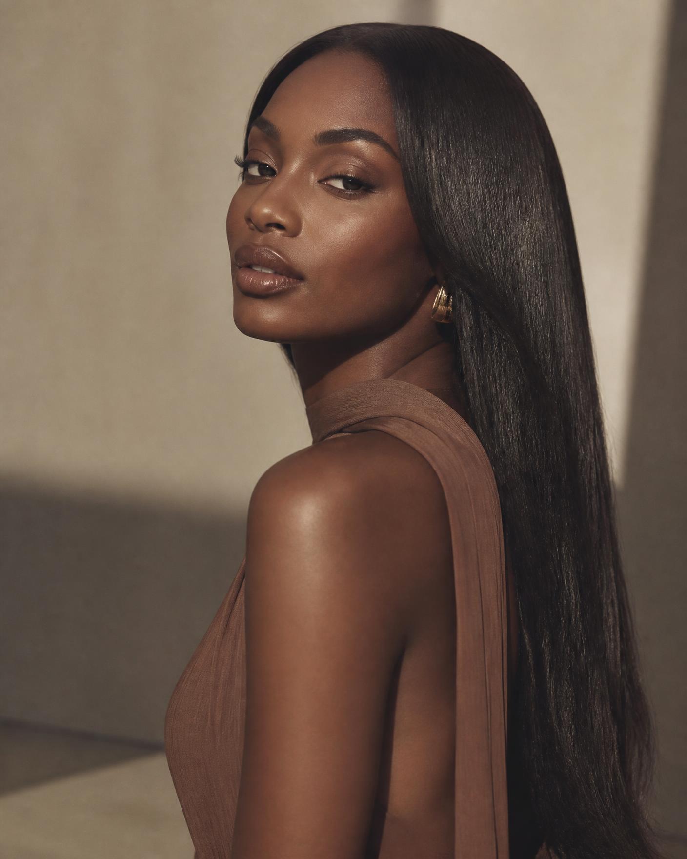 Model wearing a sleek, glossy Zefi Hairs straight wig in warm studio light